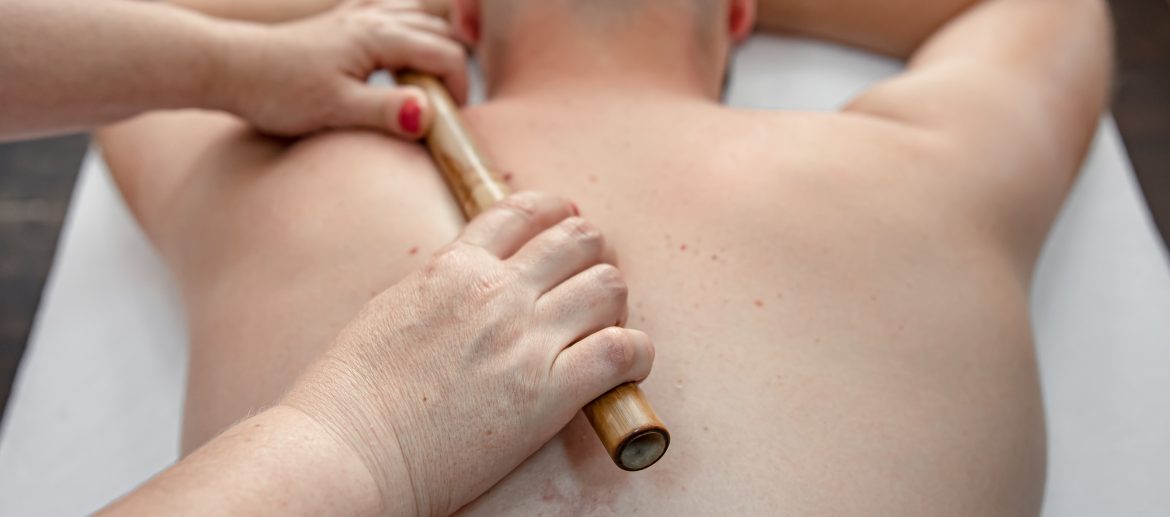The masseur using massage bamboo sticks during treatment.