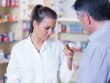 Young trainee looking at a bottle of pills in the pharmacy